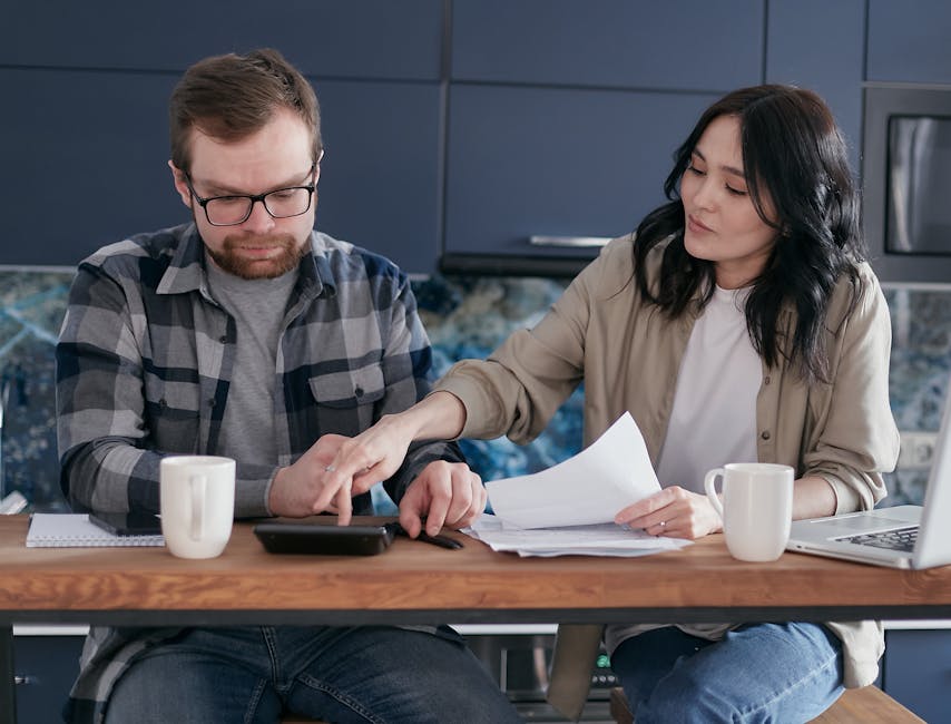 Spokojený pár ve středním věku plánuje své finance u notebooku.